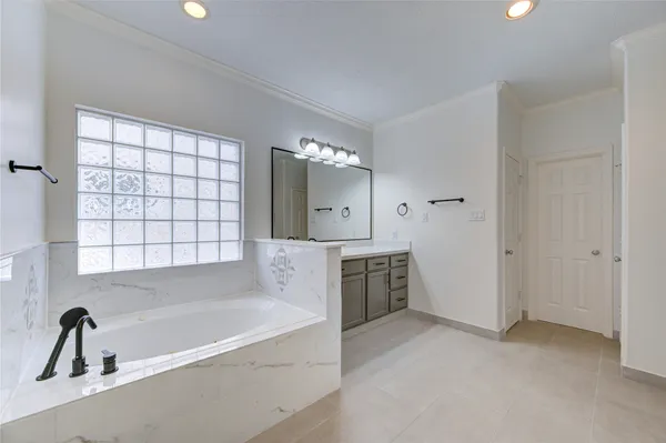 a bathroom with a tub sink and mirror