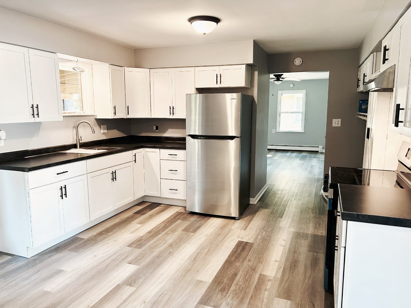 55 Cherry Drive Kankakee, IL 60901 - Photo 13 of 42 a kitchen with granite countertop a refrigerator a sink and white cabinets