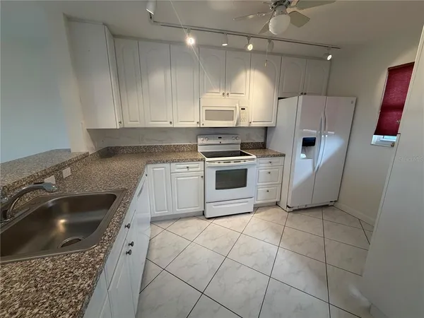 a kitchen with a stove a sink and a refrigerator