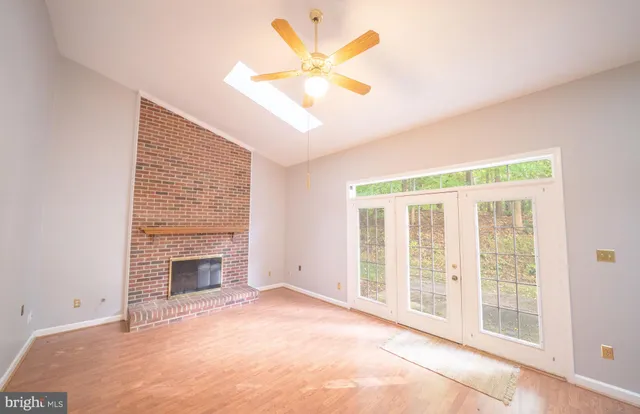 an empty room with fireplace fan and windows