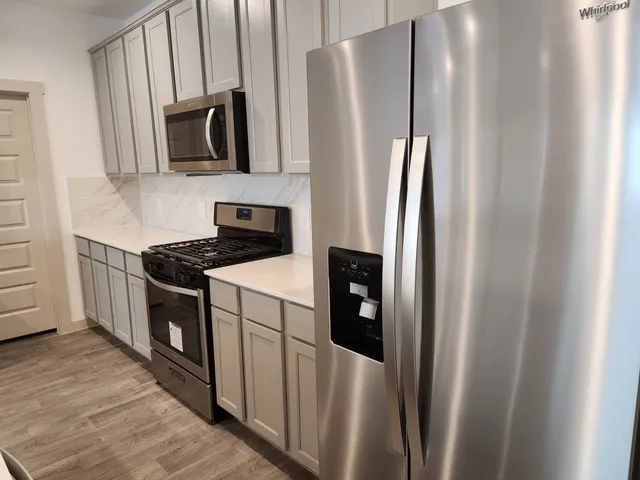 a kitchen with stainless steel appliances a refrigerator stove microwave and sink