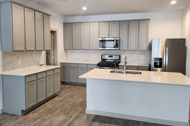 a kitchen with stainless steel appliances a refrigerator sink and stove