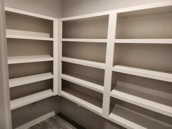 a view of walk in closet with empty racks