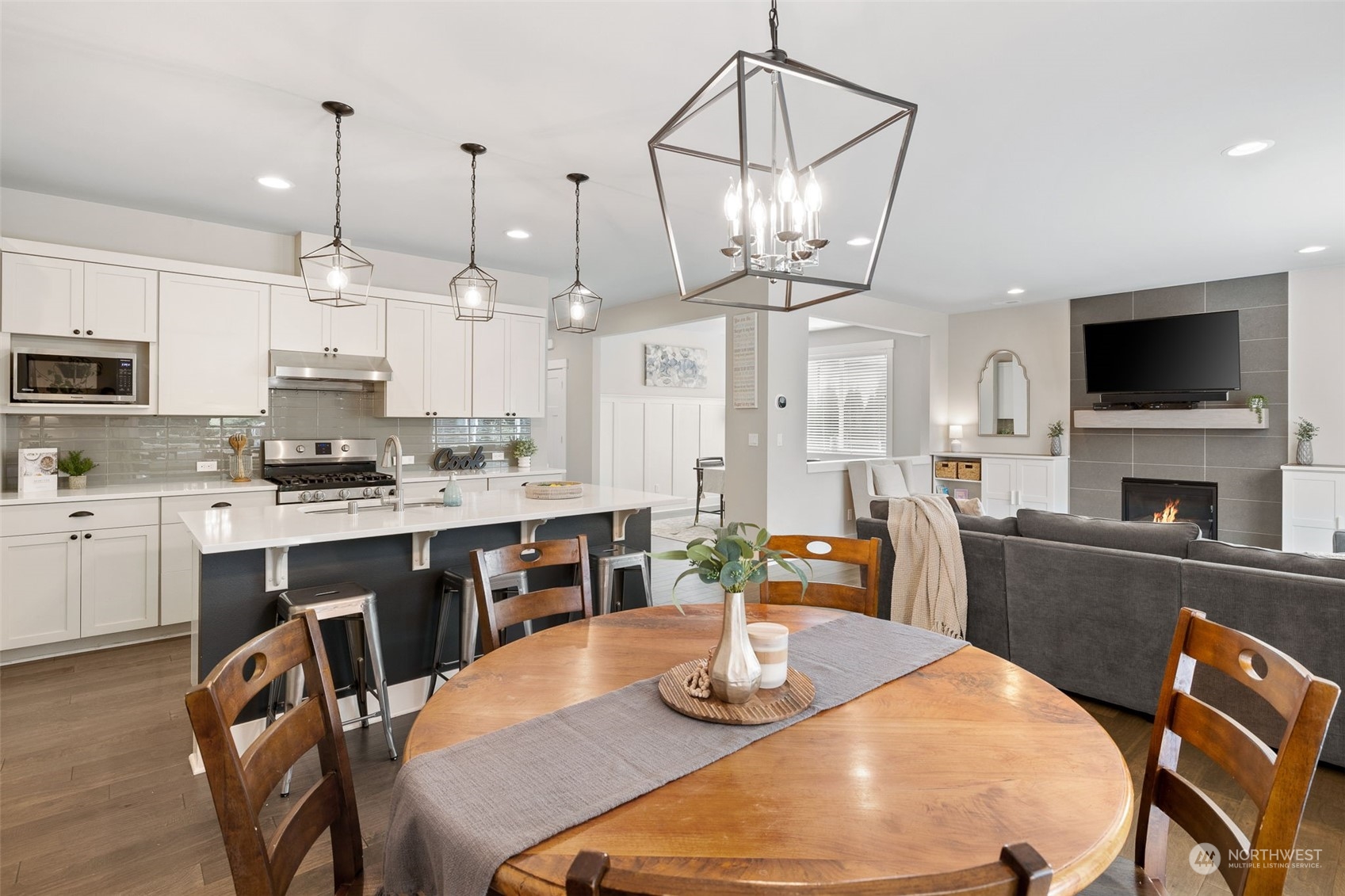 18 213th Street Southwest Bothell, WA 98021 - Photo 11 of 40 a kitchen with stainless steel appliances kitchen island granite countertop a stove a sink a dining table and chairs with wooden floor