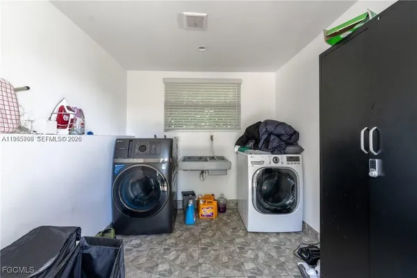 a utility room with sink dryer and washer