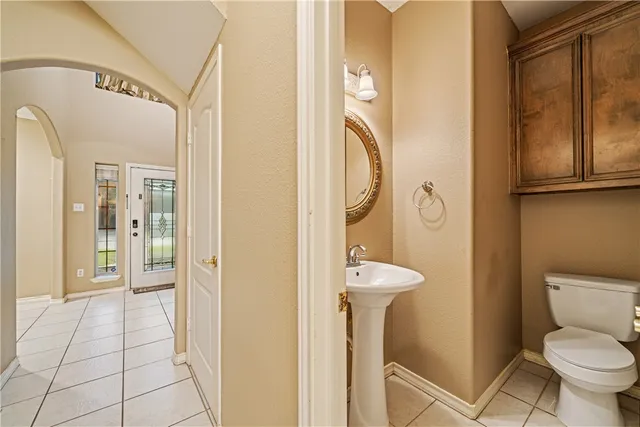 a bathroom with a toilet sink and mirror