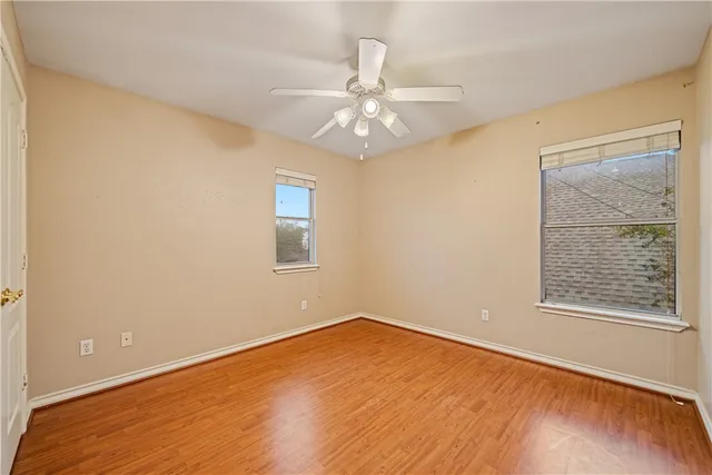 a view of an empty room with window and wooden floor