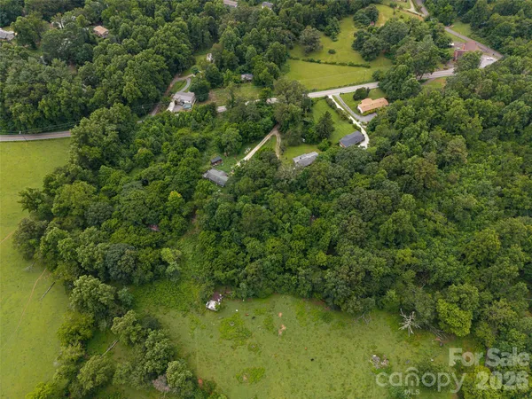 an aerial view of residential houses with outdoor space and trees