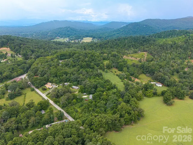 an aerial view of residential house with outdoor space and trees all around