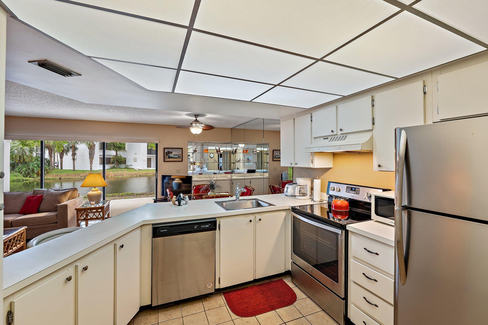 1605 Highway 1, Unit B104 Jupiter, FL 33477 - Photo 11 of 24 a kitchen with stainless steel appliances a sink cabinets and a refrigerator
