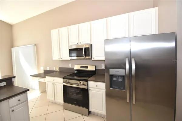 a kitchen with stainless steel appliances granite countertop a stove a refrigerator and a sink
