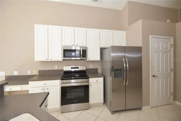 a kitchen with stainless steel appliances granite countertop a refrigerator stove and sink