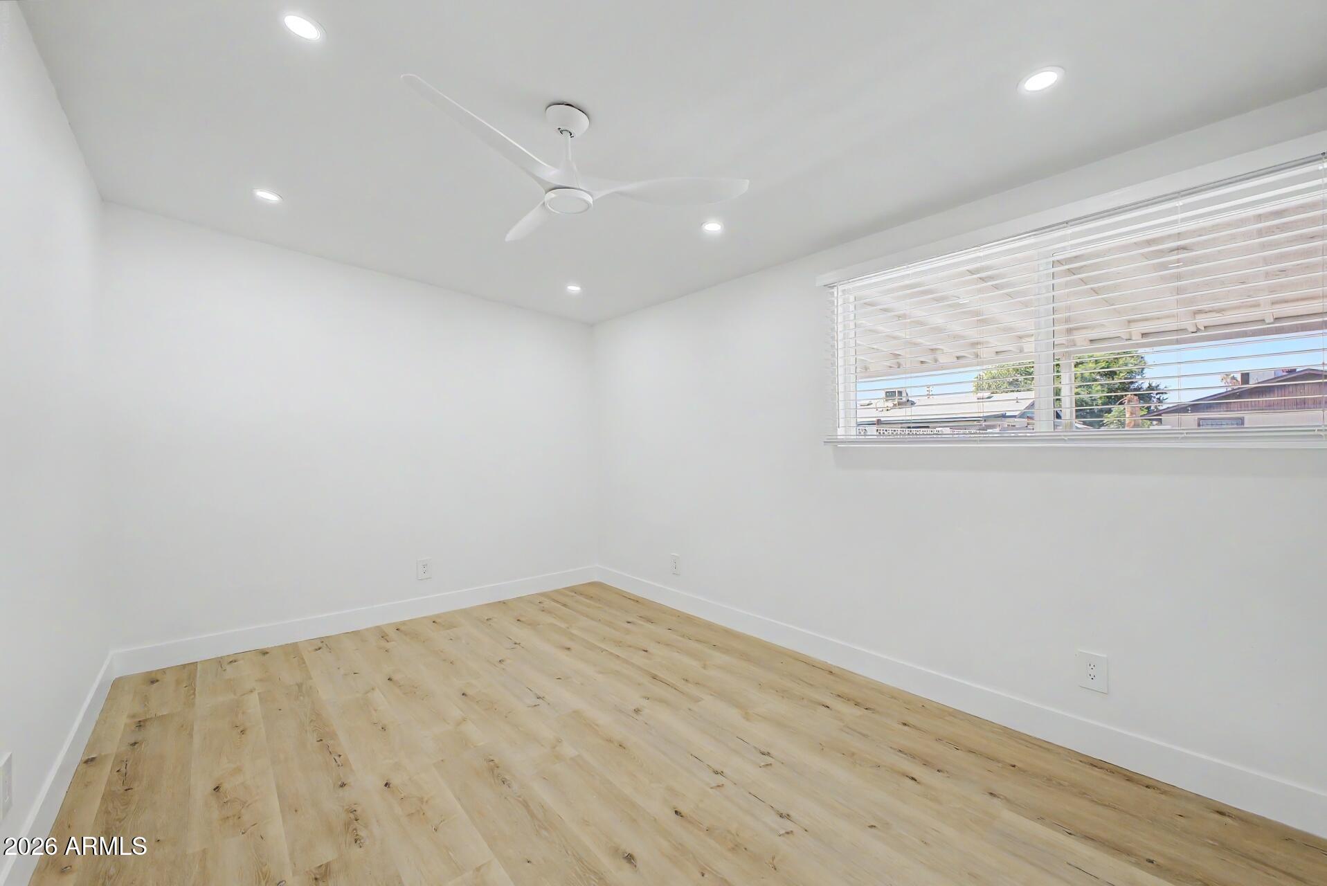 5232 West Hearn Road Glendale, AZ 85306 - Photo 21 of 32 an empty room with wooden floor and windows