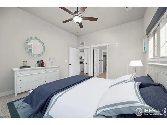 a bedroom with a large bed and a chandelier