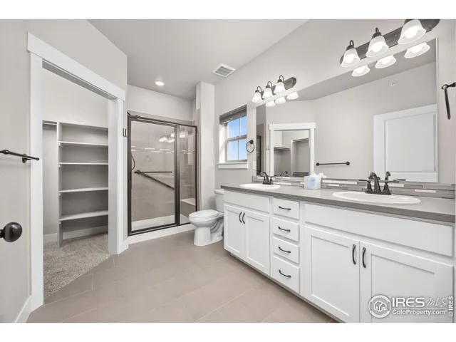 a spacious bathroom with a double vanity sink a mirror a bathtub and a shower