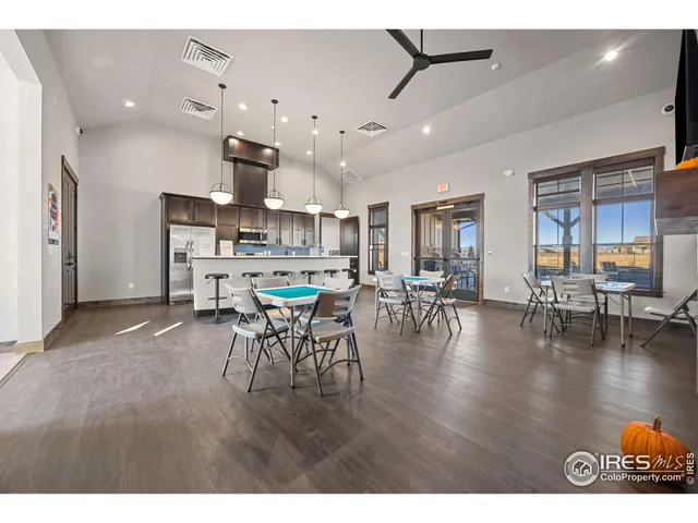 a kitchen with stainless steel appliances a dining table chairs stove and white cabinets