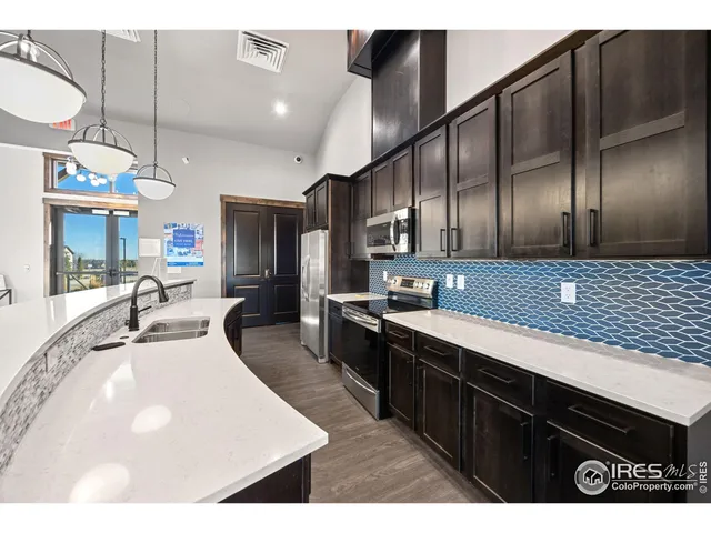 a large kitchen with stainless steel appliances kitchen island granite countertop a sink counter space and cabinets