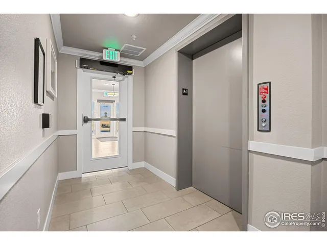 a view of kitchen with refrigerator and white cabinets