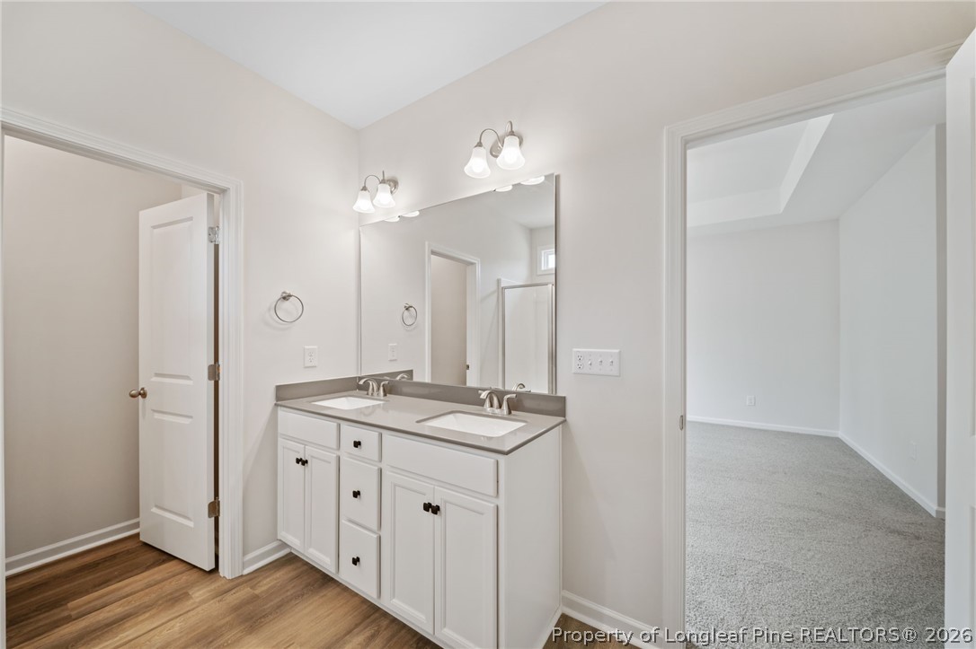 4052 Lofton Street Wade, NC 28395 - Photo 20 of 22 a bathroom with a granite countertop sink a mirror and a shower