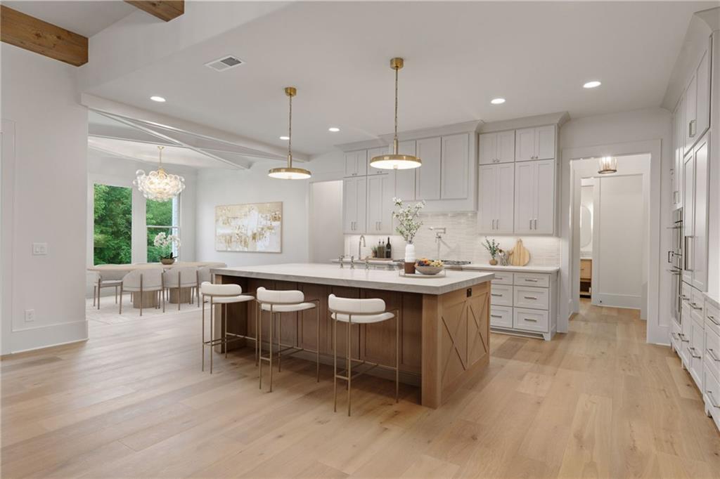 2701 Conns Creek Road, Unit 48 Ball Ground, GA 30107 - Photo 6 of 17 a large kitchen with kitchen island a sink stainless steel appliances and cabinets