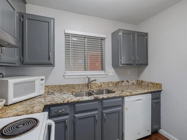 a kitchen with stainless steel appliances granite countertop a sink stove and cabinets