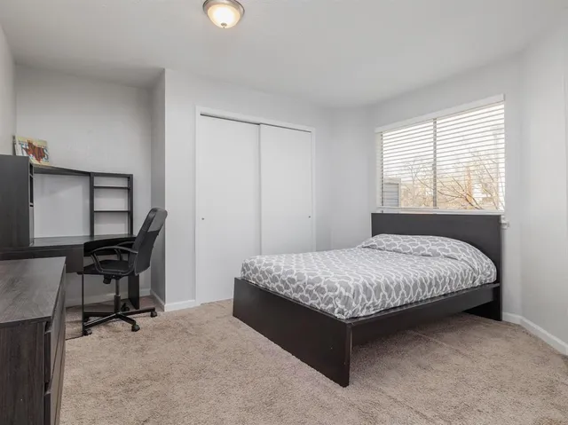 a bedroom with a bed chair and a window