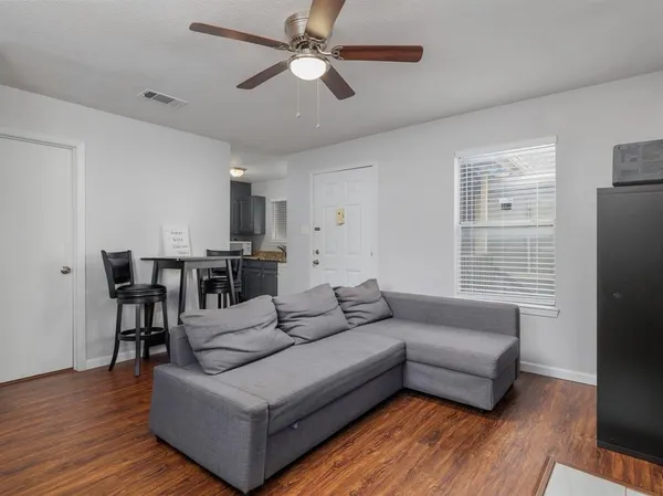 a living room with furniture and wooden floor