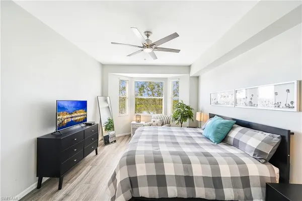 a bedroom with a bed and a flat tv screen on the dresser