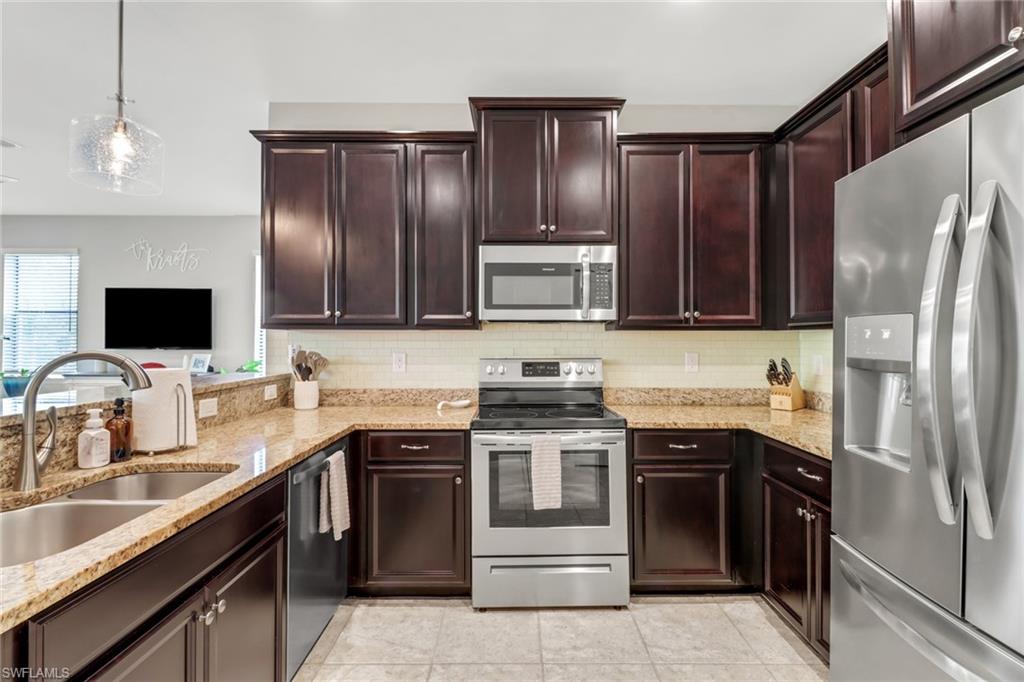 15354 Summit Pl Circle, Unit 159 Naples, FL 34119 - Photo 12 of 27 a kitchen with stainless steel appliances granite countertop a sink stove and refrigerator