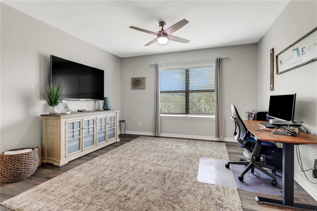 15354 Summit Pl Circle, Unit 159 Naples, FL 34119 - Photo 13 of 27 a view of a workspace with furniture and a flat screen tv
