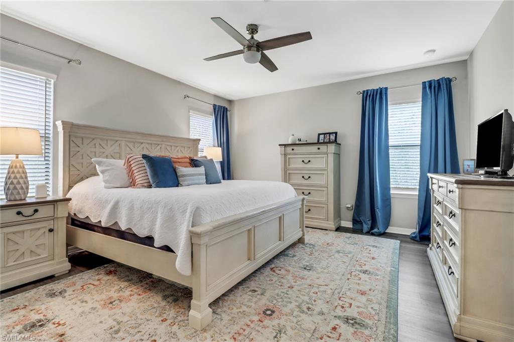 15354 Summit Pl Circle, Unit 159 Naples, FL 34119 - Photo 15 of 27 a spacious bedroom with a bed and a flat screen tv