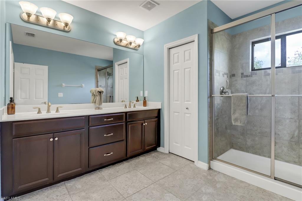 15354 Summit Pl Circle, Unit 159 Naples, FL 34119 - Photo 18 of 27 a bathroom with a sink vanity and a mirror