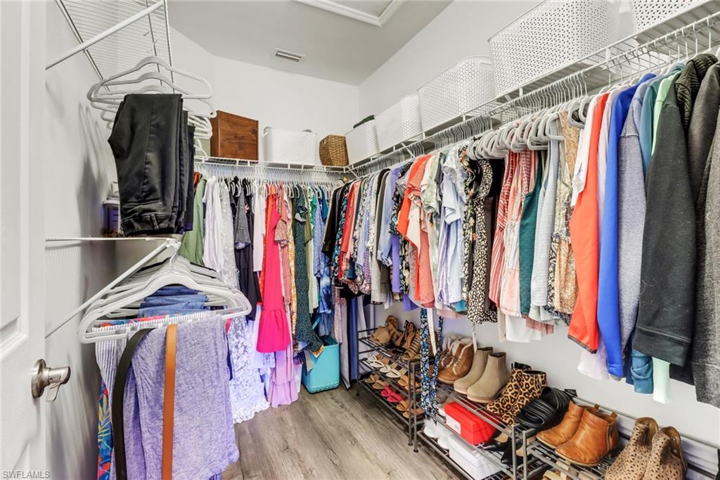 15354 Summit Pl Circle, Unit 159 Naples, FL 34119 - Photo 19 of 27 a view of walk in closet with clothes