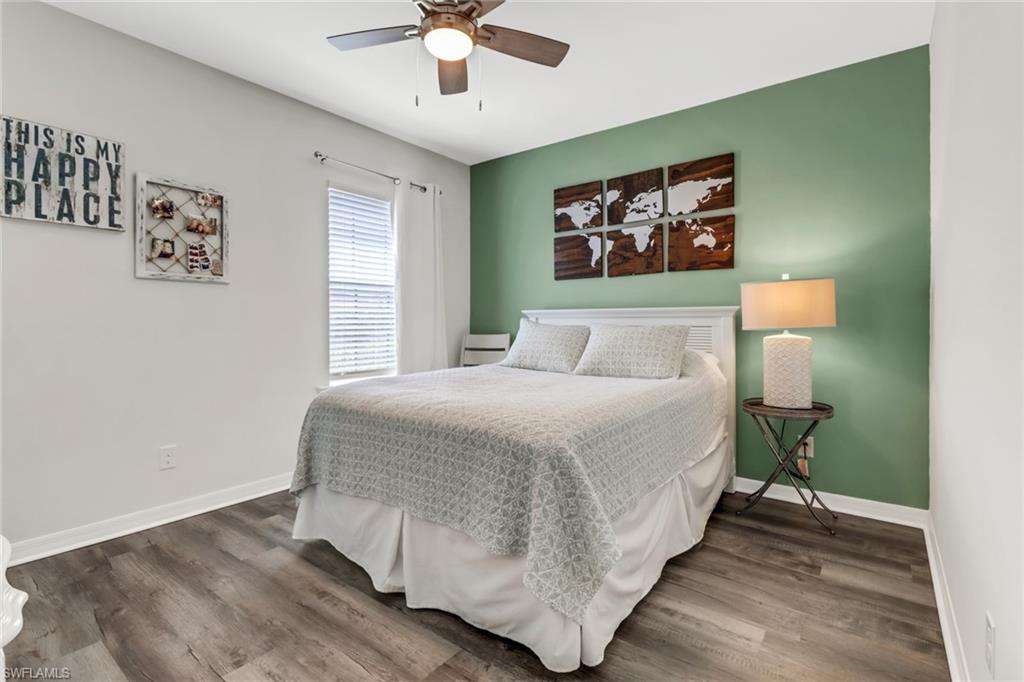 15354 Summit Pl Circle, Unit 159 Naples, FL 34119 - Photo 23 of 27 a bedroom with a large bed and a chandelier