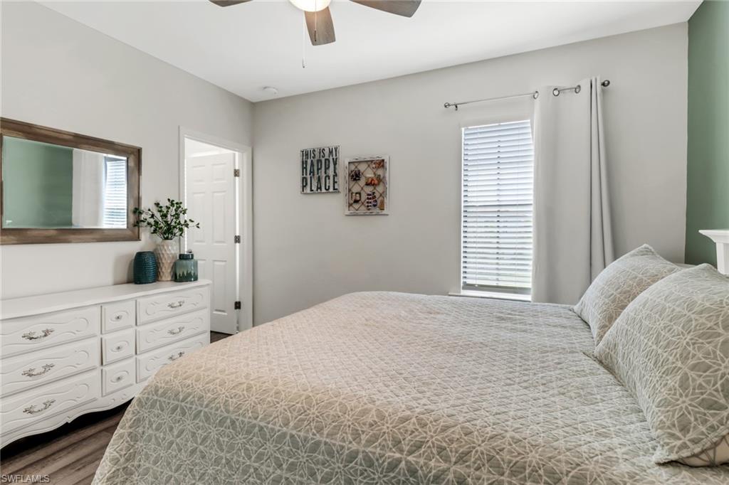 15354 Summit Pl Circle, Unit 159 Naples, FL 34119 - Photo 24 of 27 a bedroom with a bed and a dresser with mirror