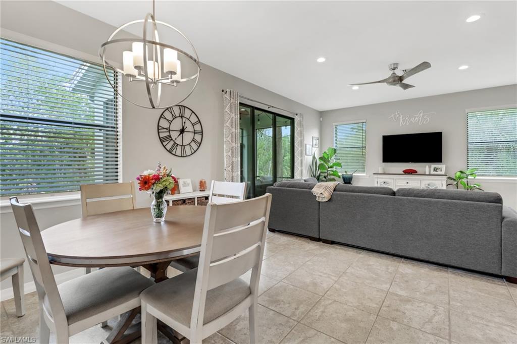 15354 Summit Pl Circle, Unit 159 Naples, FL 34119 - Photo 8 of 27 a living room with furniture a chandelier and a flat screen tv