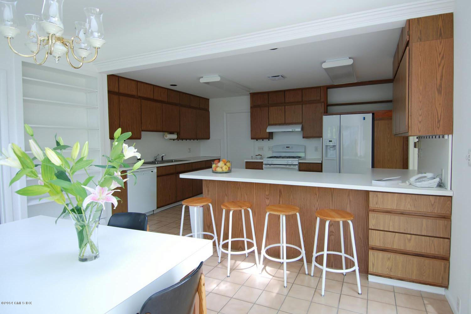 4 Ridgebrook Road Greenwich, CT 06830 - Photo 4 of 10 a kitchen with stainless steel appliances granite countertop a sink a stove a dining table and chairs