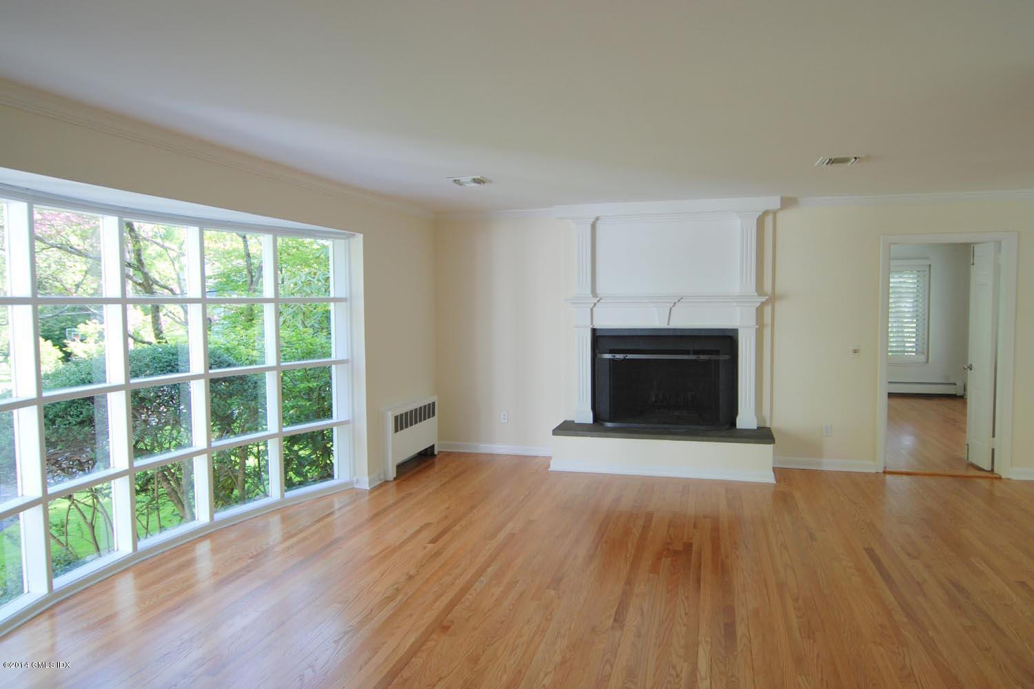 4 Ridgebrook Road Greenwich, CT 06830 - Photo 6 of 10 wooden floor fireplace and windows in an empty room