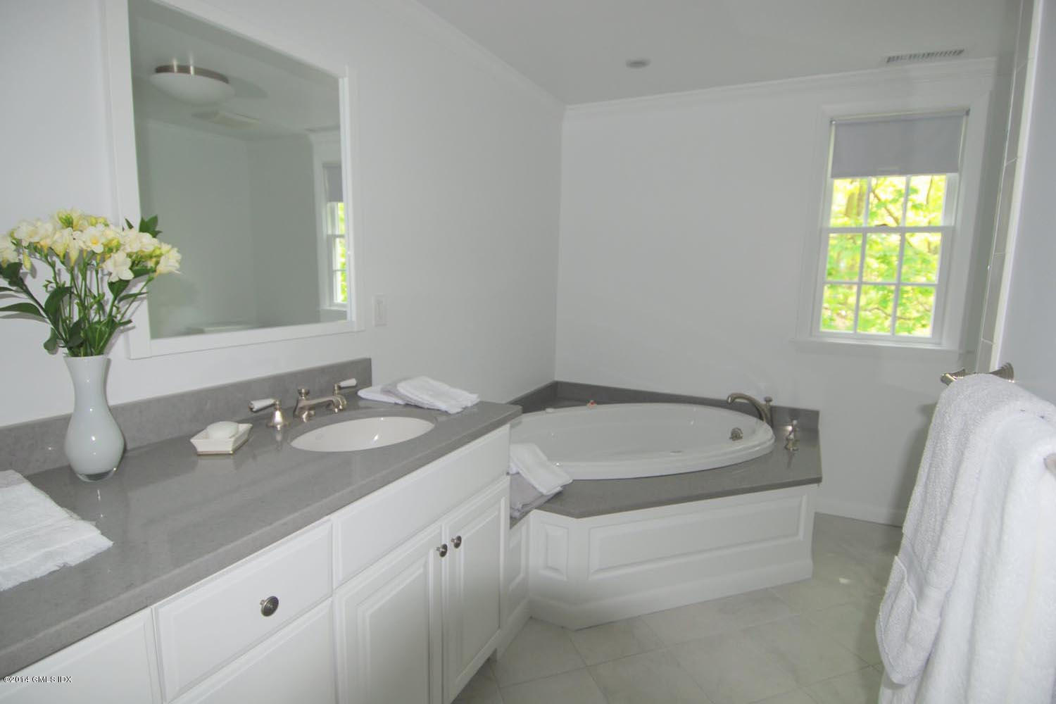 4 Ridgebrook Road Greenwich, CT 06830 - Photo 8 of 10 a spacious bathroom with a granite countertop tub sink and mirror