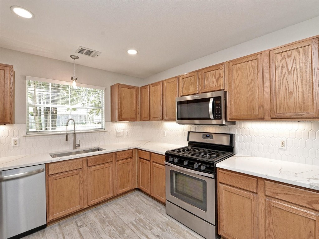 17816 Cutback Drive Manor, TX 78653 - Photo 2 of 28 a kitchen with sink a microwave and cabinets