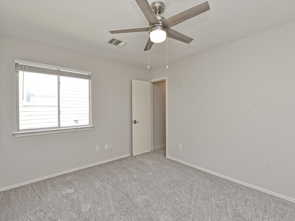 17816 Cutback Drive Manor, TX 78653 - Photo 22 of 28 an empty room with a window and a fan