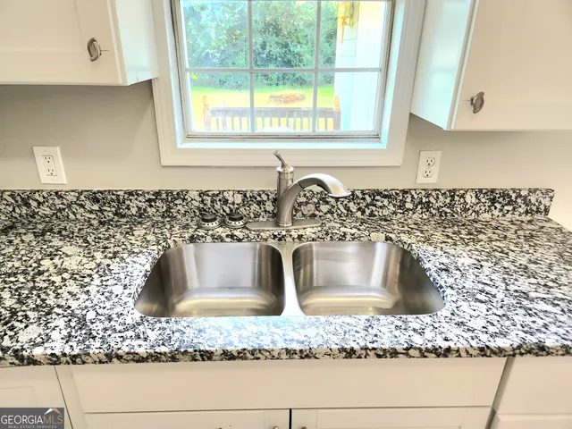 a bathroom with a granite countertop sink and window