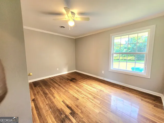 a view of an empty room and window and wooden floor