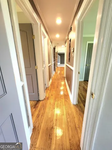 a view of a hallway with wooden floor and staircase