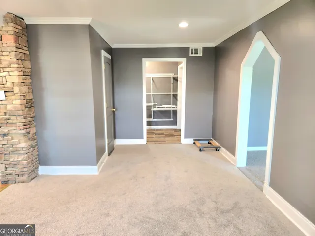 an empty room with windows and closet