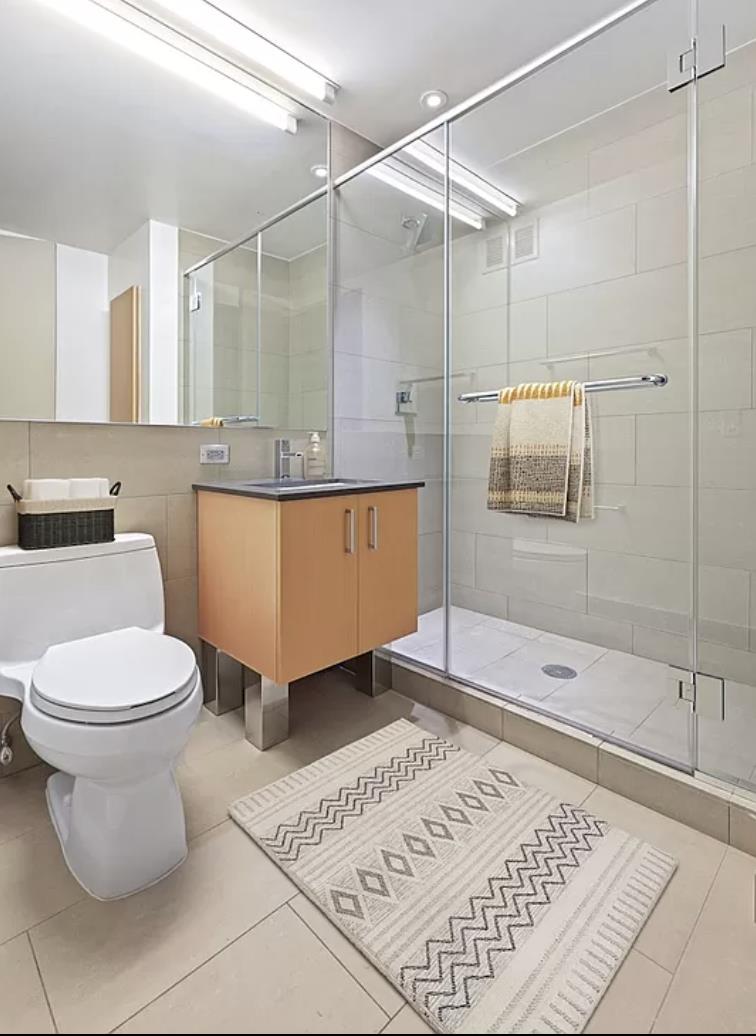 8 Spruce Street, Unit 36T Manhattan, NY 10038 - Photo 4 of 19 a bathroom with a sink a toilet and shower