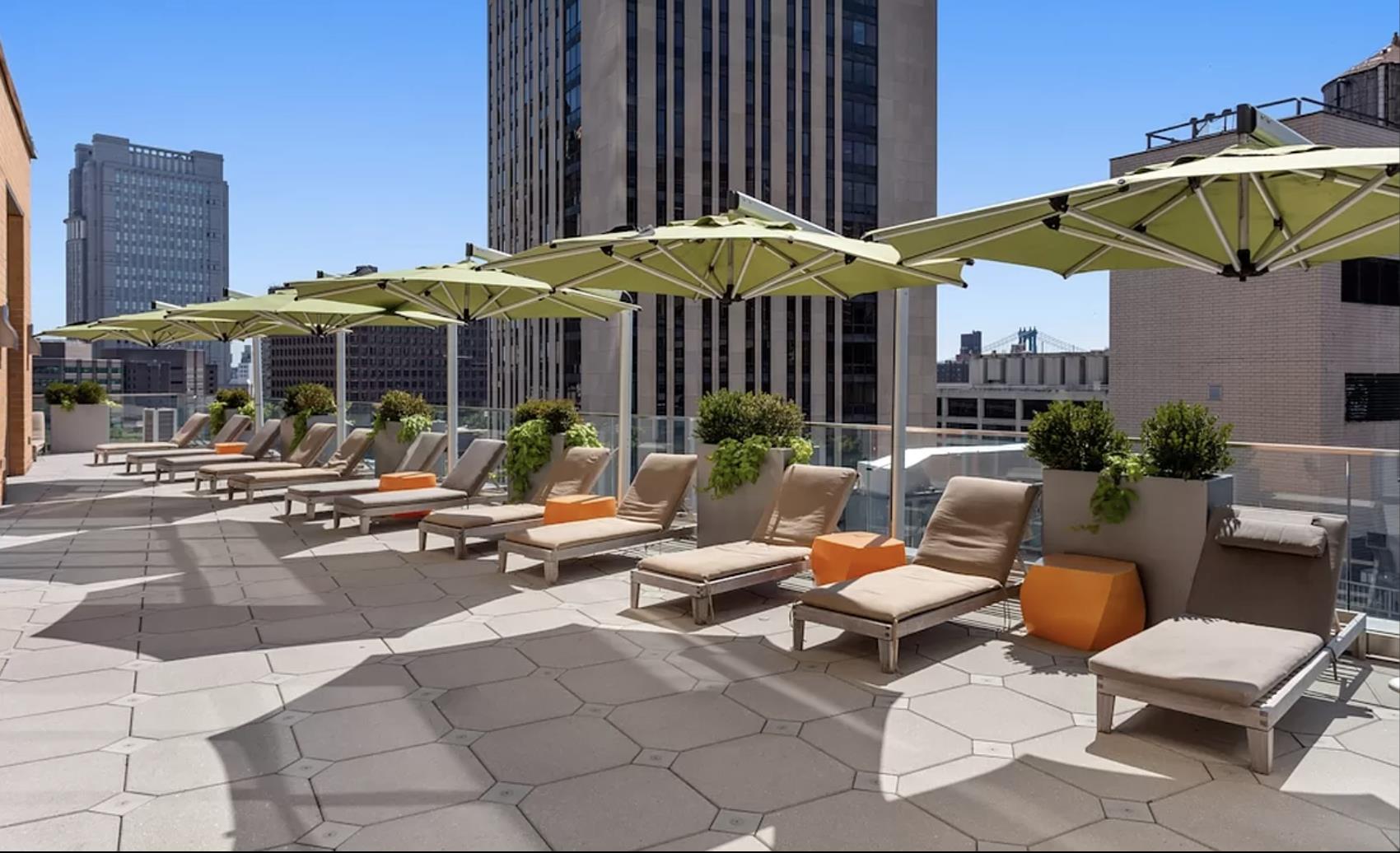8 Spruce Street, Unit 36T Manhattan, NY 10038 - Photo 9 of 19 a view of a patio with a table and chairs under an umbrella