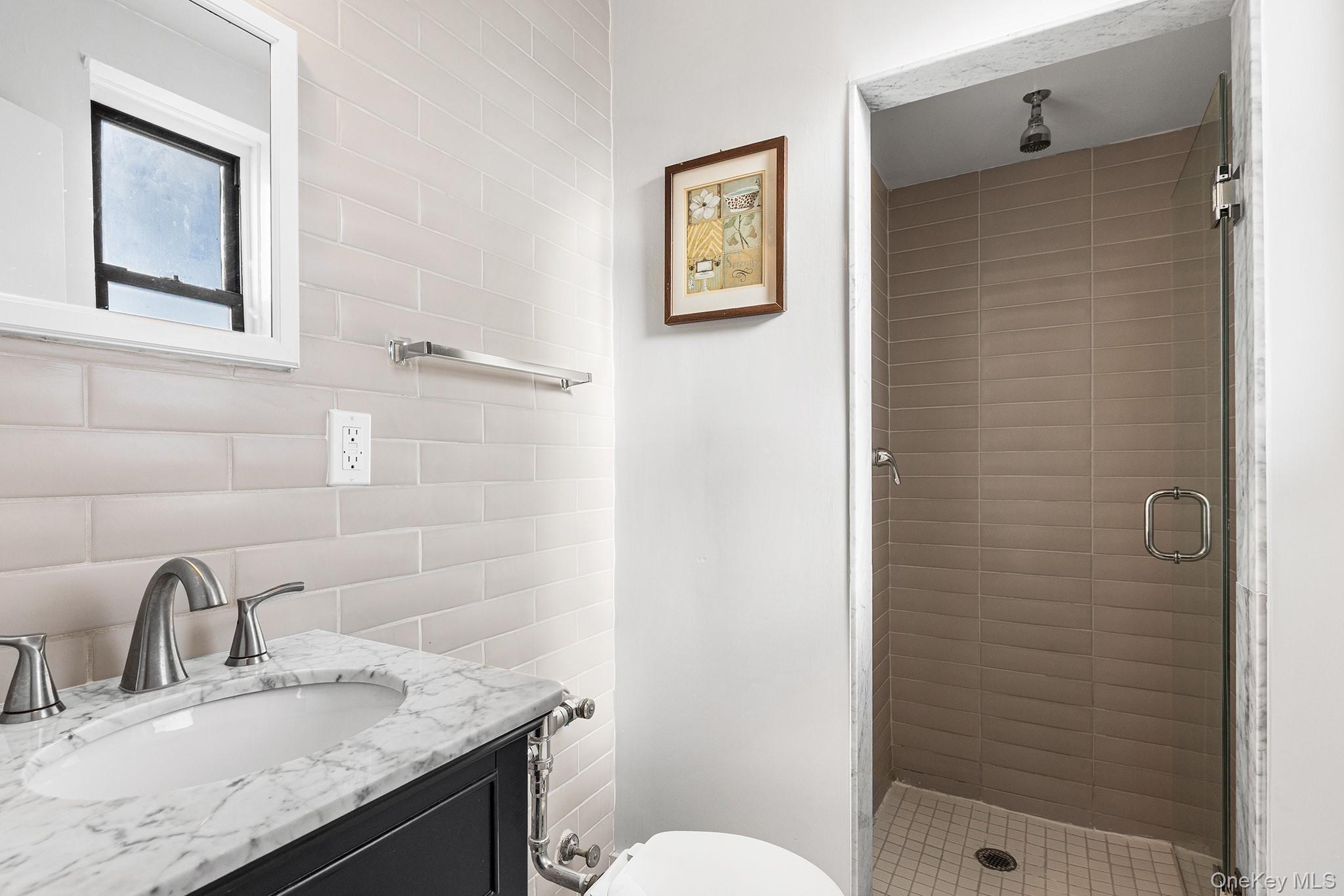 525 West 235th Street, Unit 7E Bronx, NY 10463 - Photo 11 of 14 a bathroom with a granite countertop sink toilet and shower