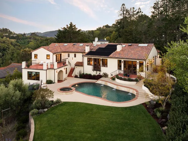 a aerial view of a house with swimming pool and a yard