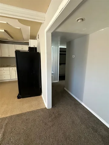 an empty room with a fan & a window